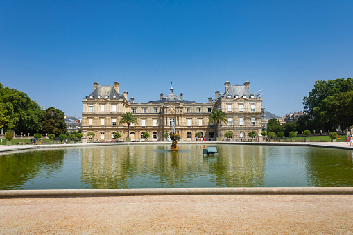 Paris, France - July 18th 2022: Luxembourg  gardens (Jardin du Luxembourg),  Luxembourg palace and a pond in front of it