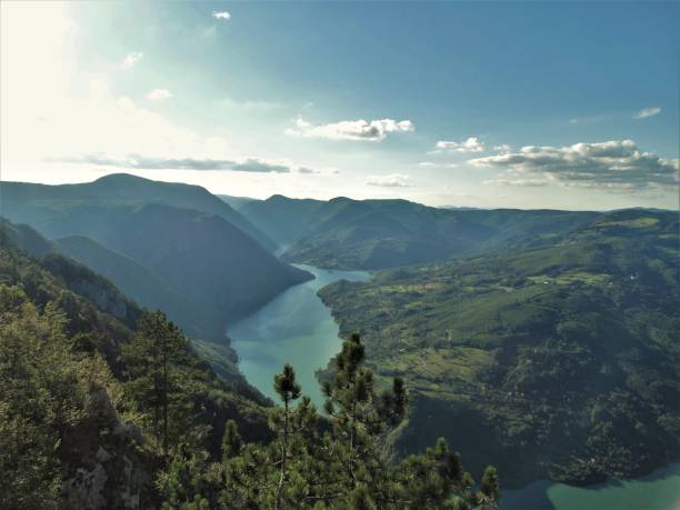 istock Beautiful scenery of river between mountains under blue cloudy sky and sunlight 1449918501