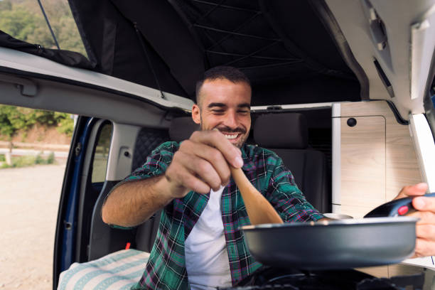istock man cooking with a frying pan in his camper van 1449920429