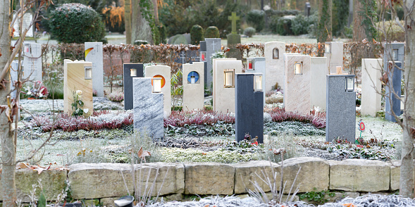 modern Bestattungsgarten in a cementery with gravestones with integrated grave lighting in winter with hoarfrost