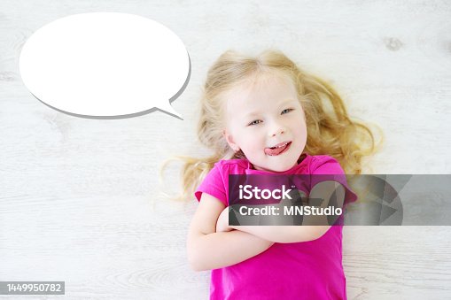 istock Little girl lying on white wooden floor with a speech bubble above her head 1449950782
