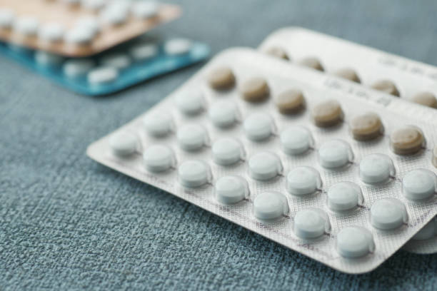 pigułki antykoncepcyjne na drewnianym tle, z bliska - contraceptive zdjęcia i obrazy z banku zdjęć