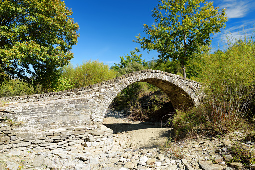 Traditional arched stone bridge of Zagori region in Northern Greece. Iconic bridges were mostly built during the 18th and 19th centuries by local master craftsmen using local stone. Epirus, Greece.