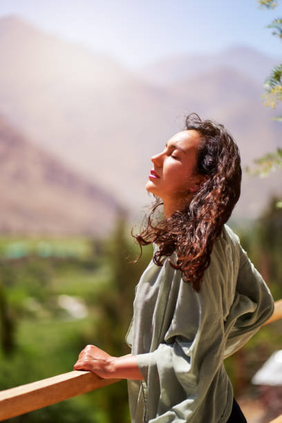 Young latin woman with eyes closed and head raised enjoying the sun and the breeze in the Valle del Elqui, Paihuano. stock photo