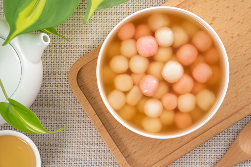 Little red and white tangyuan (tang yuan, glutinous rice dumpling balls) with sweet syrup soup in a bowl for Winter solstice festival food.