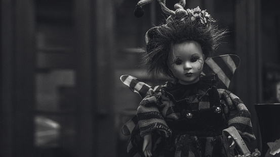 Scary children's doll from horror movies. Monochrome toy portrait..