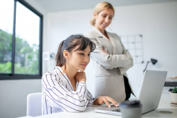istock business team female colleagues talking at work share ideas with laptop, Happy colleagues work together, CEO executive in corporate office. 1449971109