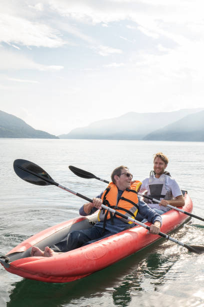 静かな湖でカヌーをする父と息子 - family kayaking kayak canoeing ストックフォトと画像