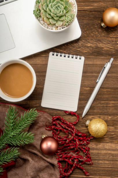 istock Christmas background with Laptop, blank notebook, fir branches, decorations. Space for text. Top view. Christmas to-do list or wish list. 1449978752