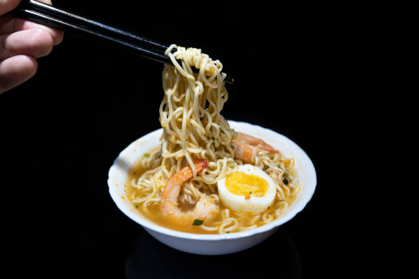 istock Spicy instant noodle with shrimp and egg on a black background. 1449987165