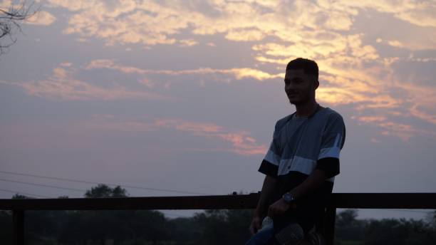 istock South East Asian guy posing against a railing against a cloudy sky at sunset 1449989200