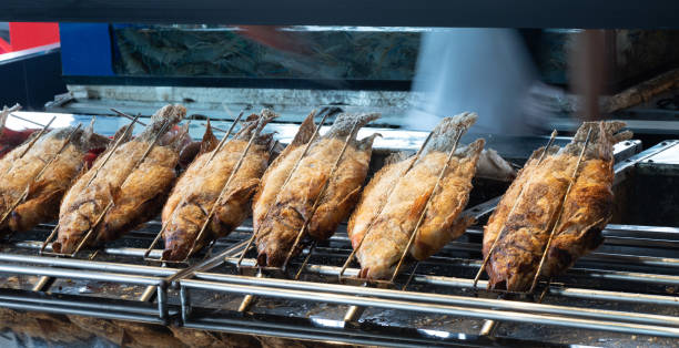 istock Freshwater fish with salt coating grilled over a wood-burning fire 1449991533