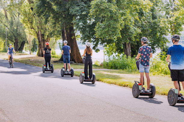 grupo de turistas em uma excursão guiada de segway no parque da cidade - segway - fotografias e filmes do acervo