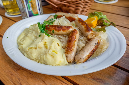 Sausage served with pickled cabbage, served with citrus mashed potatoes.
