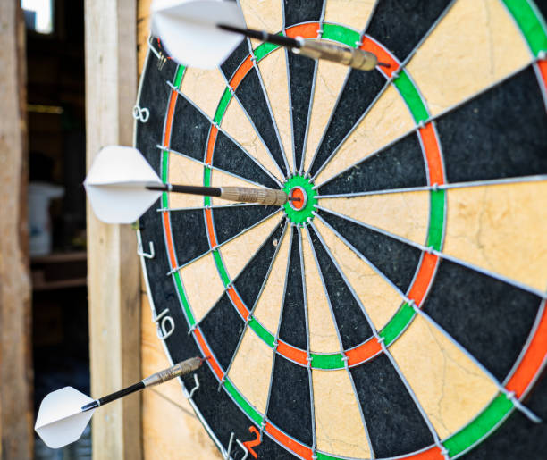 istock darts stuck in a dartboard on wooden wall 1449997725