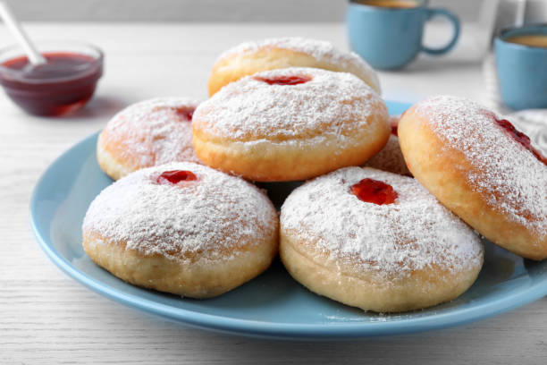 istock Delicious donuts with jam and powdered sugar on white table, closeup 1450003394