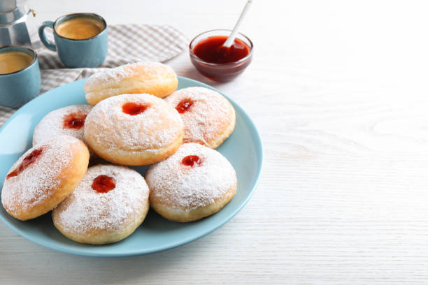 istock Delicious jam donuts served with coffee on white wooden table. Space for text 1450003629