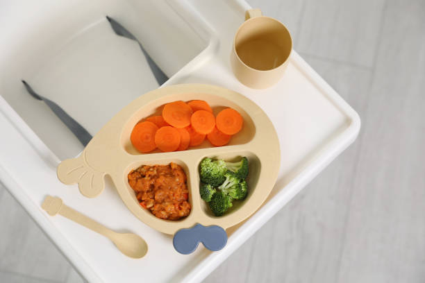 istock High chair baby tableware on white tray indoors, top view 1450003773