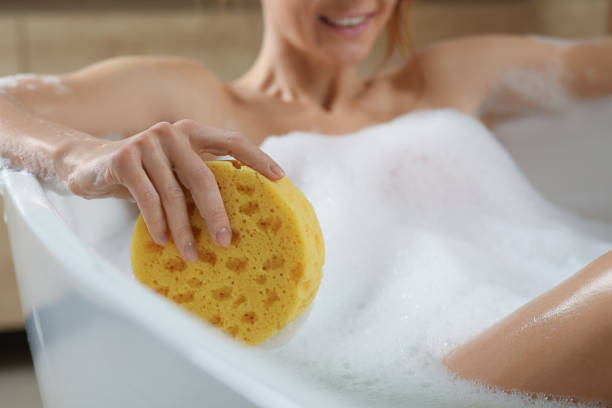 istock Woman with sponge taking bubble bath, closeup 1450004933