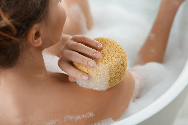 istock Woman with sponge taking bubble bath, closeup 1450005035
