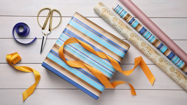 istock Flat lay composition with beautifully wrapped gift box on wooden table 1450005189