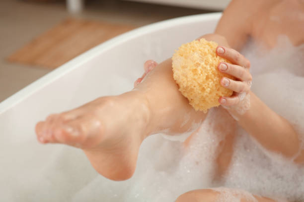 istock Woman with sponge taking bubble bath, closeup 1450005191