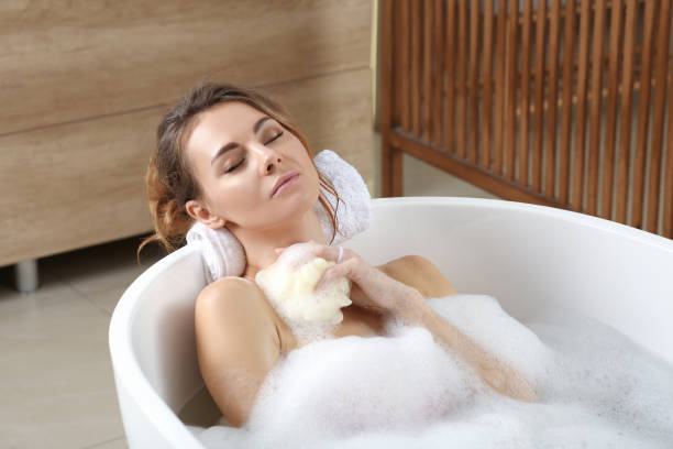 istock Beautiful woman with sponge taking bath indoors 1450005483