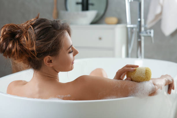 istock Beautiful woman with sponge taking bath indoors 1450006145