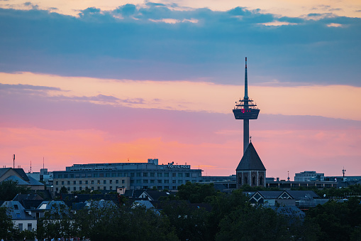 30 July 2022, Cologne, Germany: Koln Tv-tower against colorful sunset sky