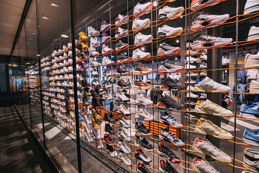 30 July 2022, Cologne, Germany: Many sports comfortable shoes or sneakers on the store counter. Fashion and footwear business concept