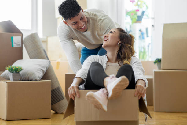 Young couple having fun while moving house stock photo