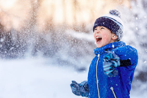 istock happy little boy having fun in the snow 1450009902