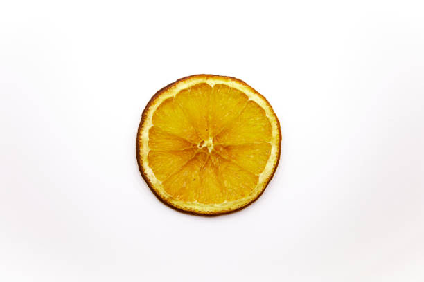 Dry orange slices in plate on wooden background