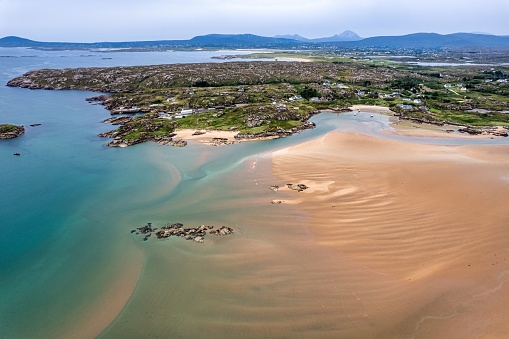 An aerial shot of the Atlantic ocean meeting the sandy shores of the County Donegal in Ireland on