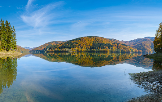 Small lake surrounded by colorful autumn trees.