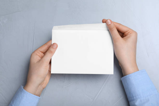istock Woman with envelope at grey table, top view 1450015681