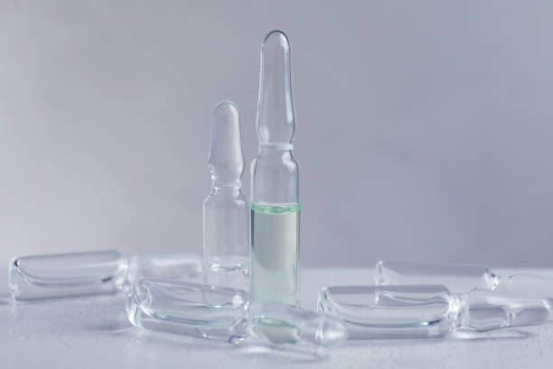 istock Pharmaceutical ampoules with medication on white table against light background 1450015956