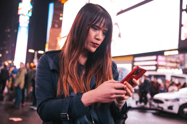 istock Woman texting on mobile in Times Square 1450015992