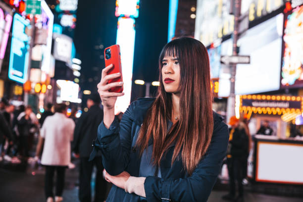 istock Woman texting on mobile in Times Square 1450016079
