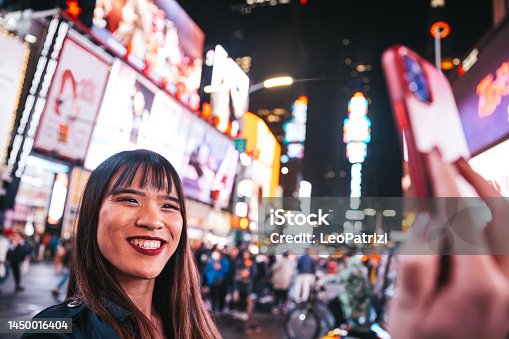 istock Happy woman take a selfie in Times Square to share on social media 1450016404
