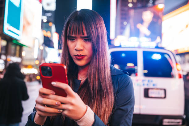 istock Woman texting on mobile in Times Square 1450016480