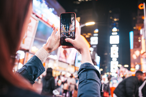 Tourist take a snapshot in midtown Manhattan to the always crowded Times Square.