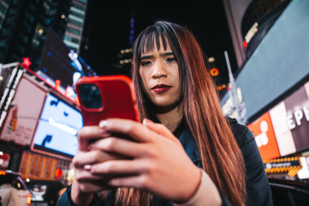 istock Woman texting on mobile in Times Square 1450017086
