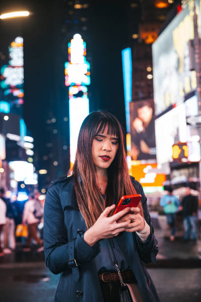 istock Woman texting on mobile in Times Square 1450017284