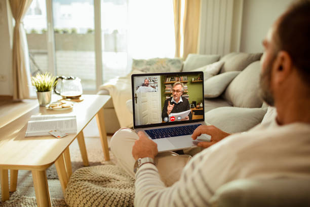 Mid adult man talking to his therapist online Close up of a mid adult man using his laptop to talk to his therapist melancholy computer support specialist stock pictures, royalty-free photos & images