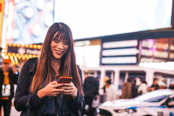 istock Woman texting on mobile in Times Square 1450017486