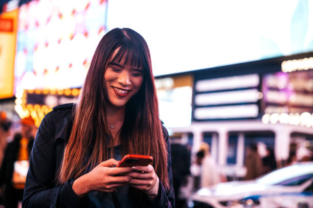 istock Woman texting on mobile in Times Square 1450017633