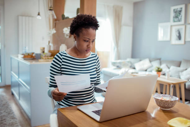 istock Young woman going over her home finances during breakfast 1450018219