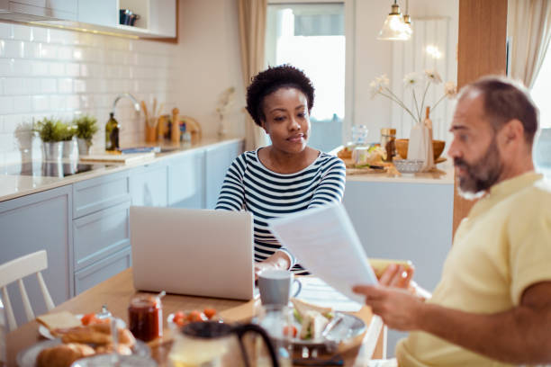 istock Mid adult couple going over their home finances while having breakfast 1450018409