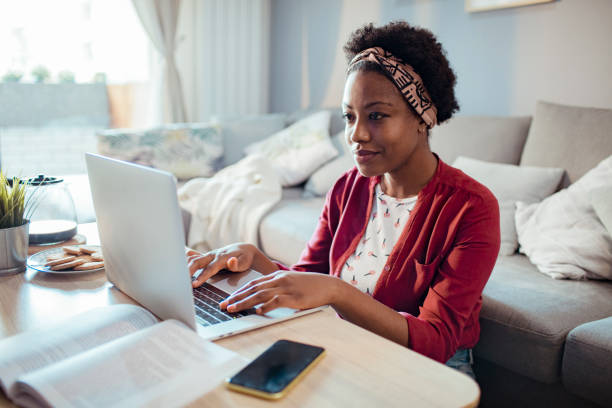istock Young adult woman using her laptop 1450018585